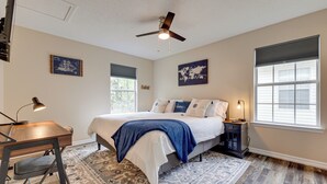 A bedroom with a bed, bedside table, lamp, and a ceiling fan. - Charming Biloxi Vacation Rental Near Beach! (Biloxi)