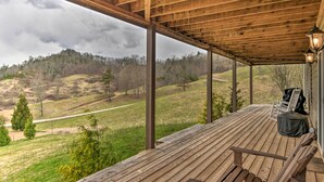 Un espacio al aire libre techado con suelo de madera, un banco y una silla.