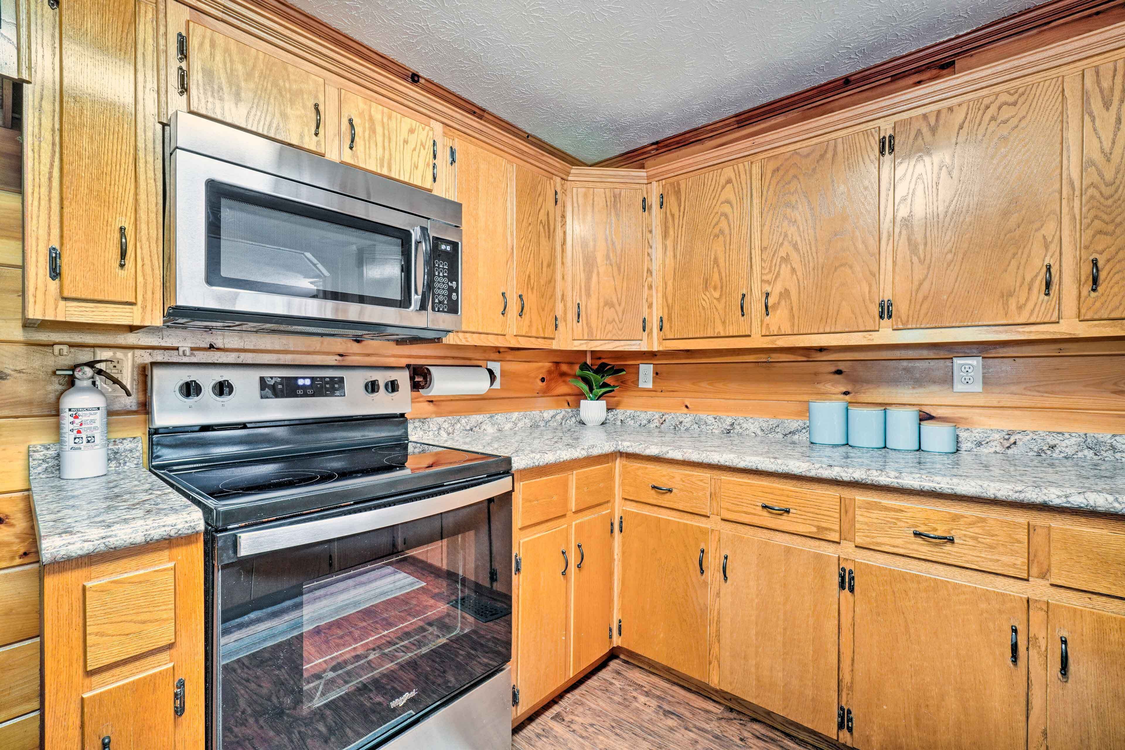 A kitchen with wooden cabinets, a stainless steel microwave, and a black oven.