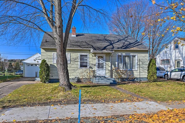 A two-story house with a front porch, a garage, and a well-maintained lawn. - Charming Family Home ~ 4 Mi to Granite Peak! (Wausau)