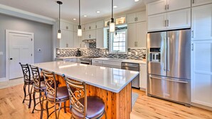 A modern kitchen with a central island, stainless steel appliances, and pendant lighting. - Charming Lake Erie Getaway: Walk to Beach! (North East)