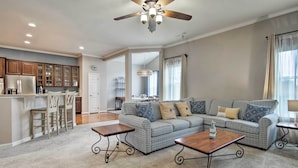 A spacious living room with a large patterned sofa, two coffee tables, and a ceiling fan. - Great for Groups: Bayside Resort Home w/ Patio (Selbyville)