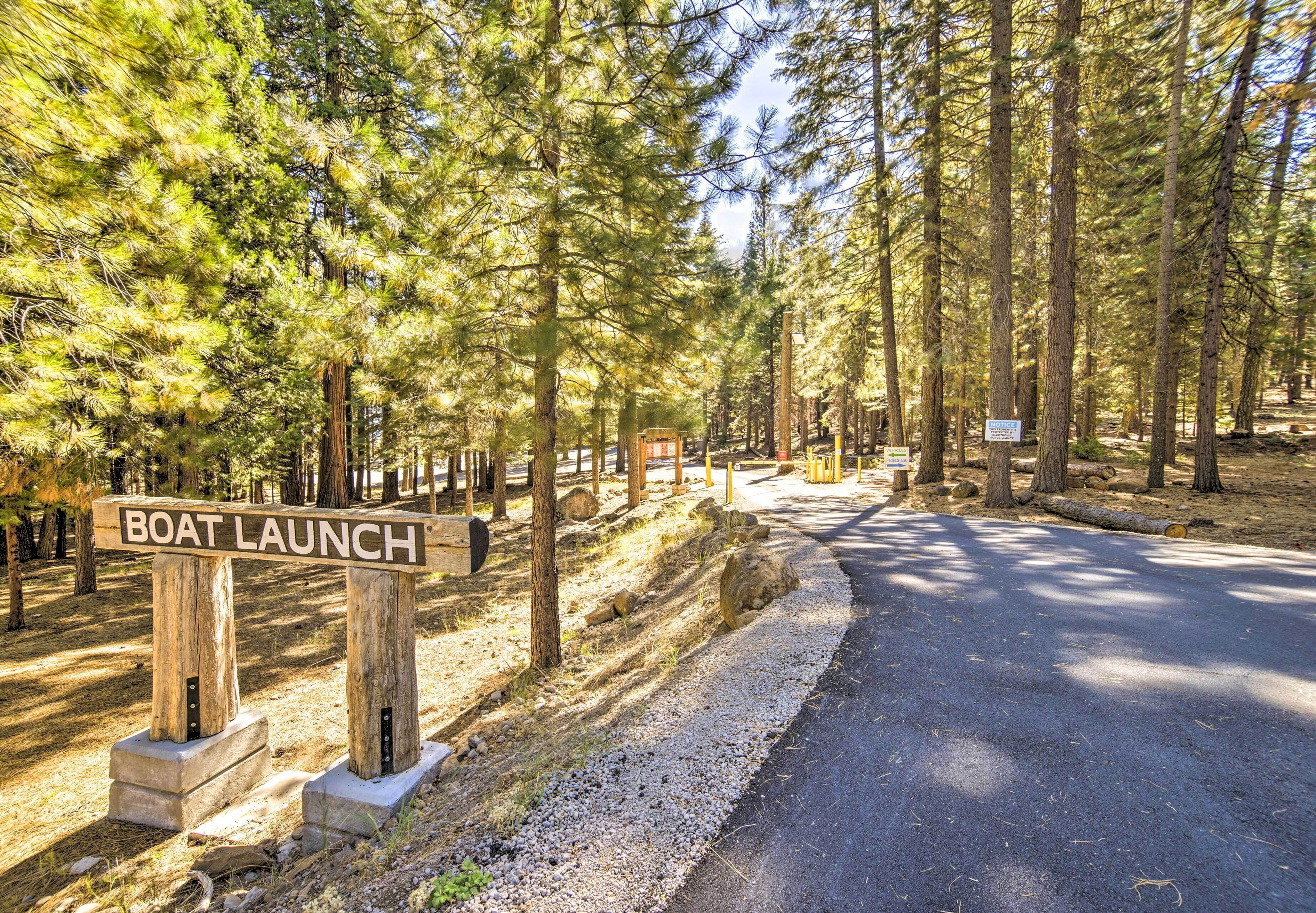 Área arborizada com placa indicando acesso para barcos.