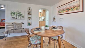 A dining area with a round wooden table, cushioned chairs, and a view into the kitchen. - Central Boise Home Near Bsu, 1 Mi to Dtwn! (Boise)