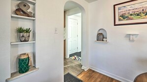 A hallway with white walls, wooden flooring, and shelves with decorative items. - Central Boise Home Near Bsu, 1 Mi to Dtwn! (Boise)