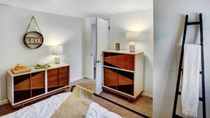 A bedroom with a bed, a dresser, a mirror, and a door. - Chic Troy Home Near Downtown, 9 Mi to Albany! (Troy)