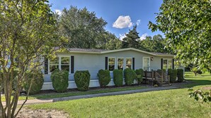 A single-story house with a front porch, a small deck, and a well-maintained lawn. - Charming Burdett Home With Grill, Gazebo + Yard (Burdett)