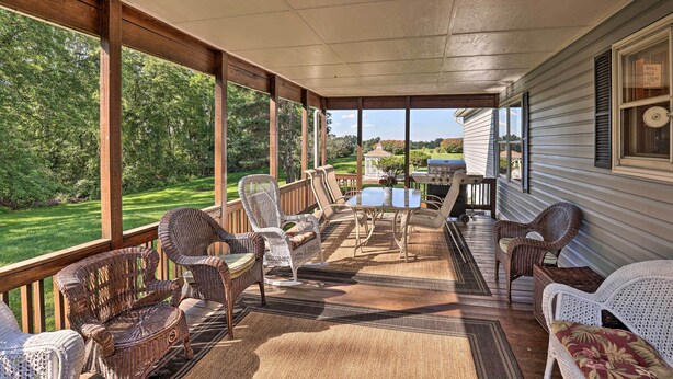 A covered porch with wicker furniture, a table, and a grill. - Charming Burdett Home With Grill, Gazebo + Yard (Burdett)