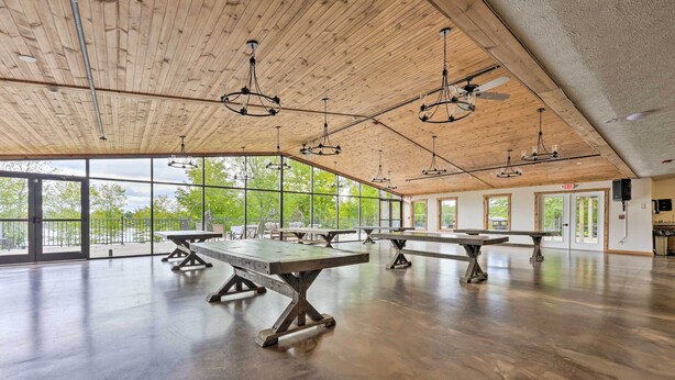 Un vaste espace intérieur doté de hauts plafonds, de grandes fenêtres et de nombreuses tables.