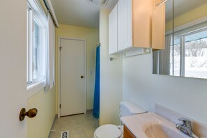 Een badkamer met toilet, wastafel en kast.