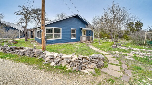 A single-story blue house with a stone pathway leading to the front door. - Cozy Kerrville Guest Cottage Near Guadalupe River! (Kerrville)