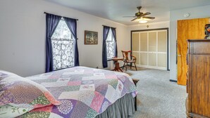 A bedroom with two beds, a ceiling fan, a wooden chair, and a door leading to a closet. - Cozy Kerrville Guest Cottage Near Guadalupe River! (Kerrville)