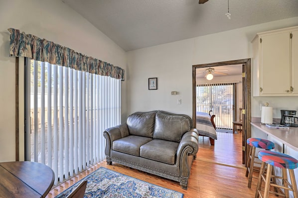 A living room with a leather sofa, a wooden coffee table, and a patterned rug. - 'cozy Cottage' w/ Shared Dock on Dawson Creek (Oriental)