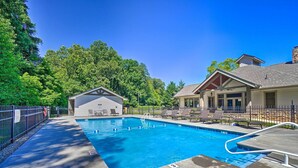 A swimming pool with lounge chairs and a covered area, surrounded by a fence and trees. - Cozy Townsend Condo, Resort-style Amenities! (Townsend)