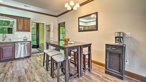A kitchen with wooden cabinets, a bar stool seating area, and a coffee maker. - Cozy Townsend Condo, Resort-style Amenities! (Townsend)