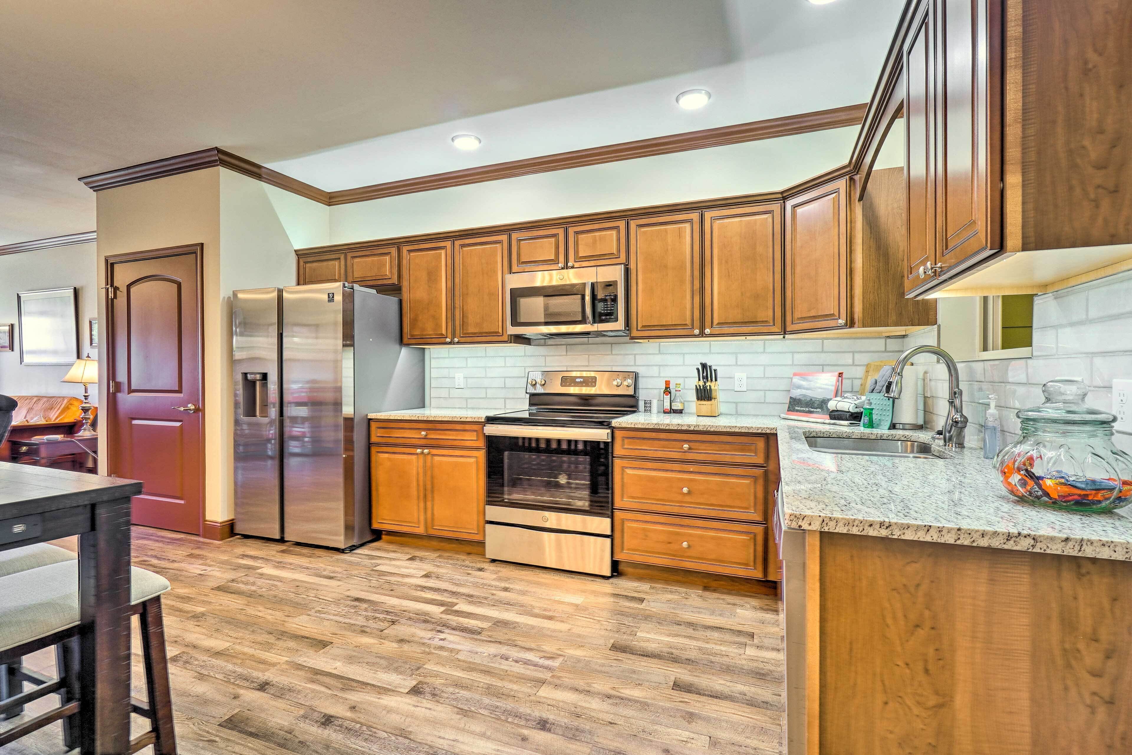 A modern kitchen with wooden cabinets, stainless steel appliances, and a granite countertop.