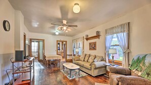 A living room with a ceiling fan, a sofa, a coffee table, and a TV on a stand. - Family-friendly Marlinton Home: Walk Downtown! (Marlinton)