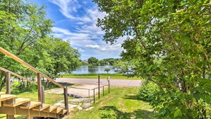 A wooden staircase leading to a lakeside area with a paved path and a lamp post. - Cozy Ishpeming Cottage w/ Lake & Park Views! (Ishpeming)