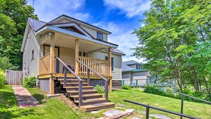 A two-story house with a front porch, wooden steps, and a stone pathway leading to the door. - Cozy Ishpeming Cottage w/ Lake & Park Views! (Ishpeming)