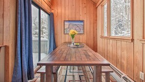A wooden interior with a table, a vase with flowers, and a framed picture on the wall. - Walk to Ski Trails: Ludlow Home on Okemo Mountain! (Ludlow)