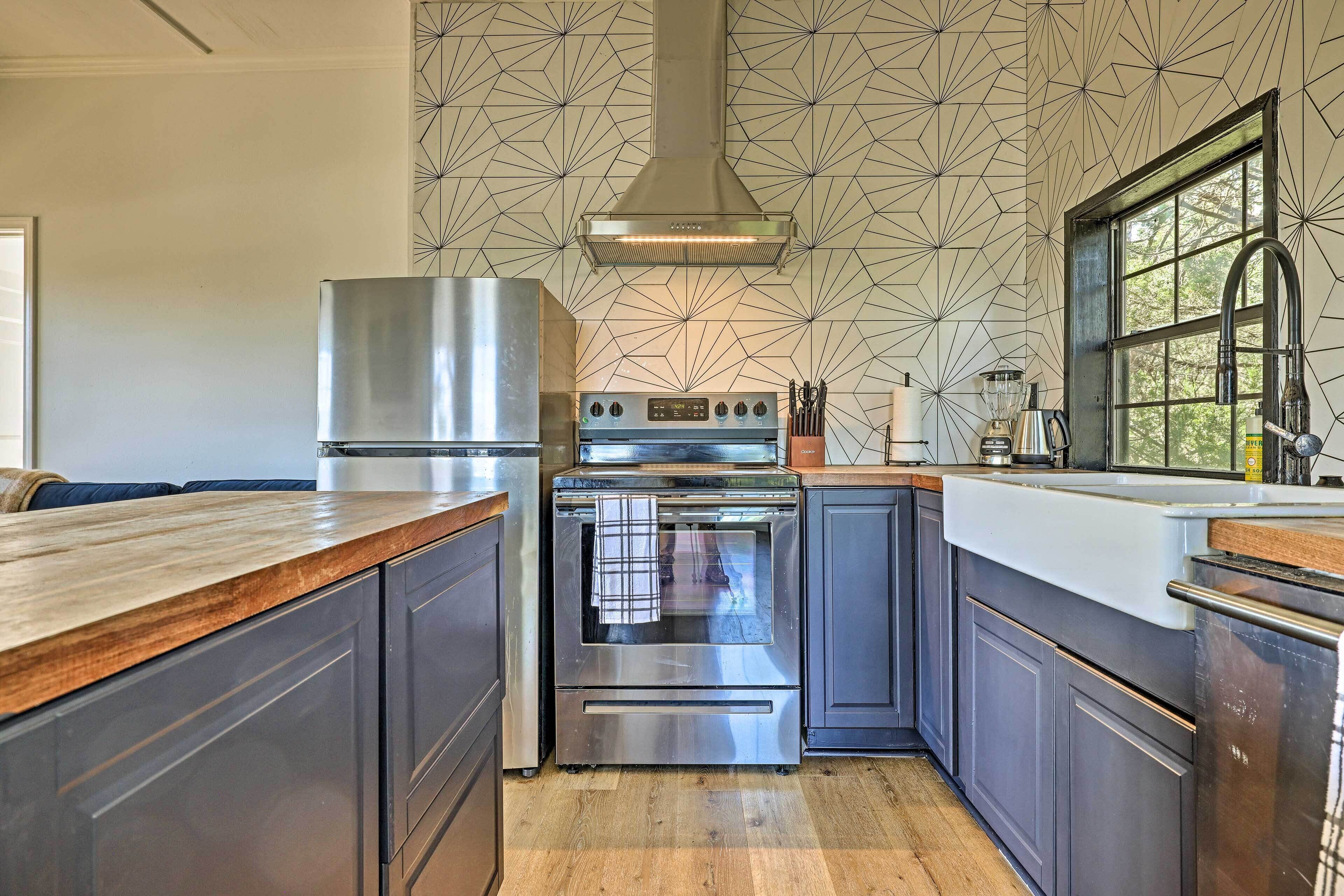 Una cocina moderna con extractor de acero inoxidable, horno doble y un amplio ventanal que proporciona luz natural.