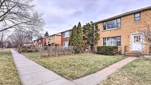 A row of townhouses with a paved walkway and a small grassy area in front. - Cozy Milwaukee Home: 3 Mi to Whitefish Bay! (Milwaukee)