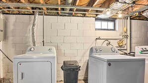 A laundry room with two washing machines, a trash bin, and a window. - Cozy Milwaukee Home: 3 Mi to Whitefish Bay! (Milwaukee)
