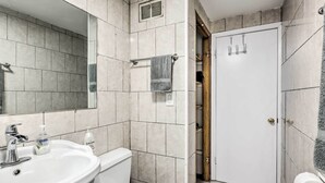 A bathroom with a sink, toilet, and shower area. - Cozy Milwaukee Home: 3 Mi to Whitefish Bay! (Milwaukee)
