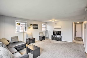 A modern living room with a sectional sofa, a coffee table, a TV, and a floor lamp.
