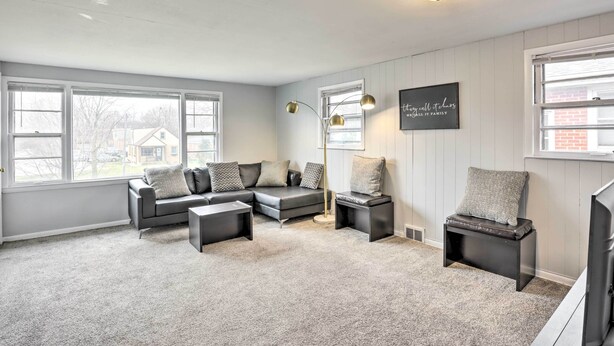A living room with a sectional sofa, a coffee table, and a side table. There is a wall-mounted light fixture and a framed quote on the wall. - Cozy Milwaukee Home: 3 Mi to Whitefish Bay! (Milwaukee)
