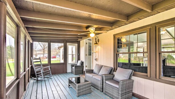 A covered porch with wicker furniture, a glass coffee table, and a ceiling fan. - Cozy Sherrodsville Home: Walk to Lake Atwood! (Sherrodsville)