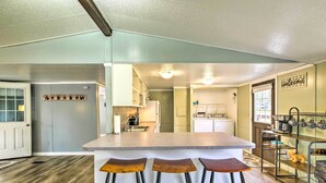 A kitchen with a bar area, wooden flooring, and a white door. - Cozy Sherrodsville Home: Walk to Lake Atwood! (Sherrodsville)