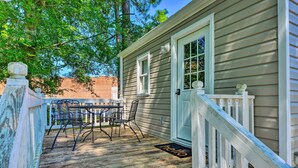 A wooden deck with a table and chairs, a white door, and a 'hello' mat. - Cozy Pantego Cottage ~ 5 Miles to Belhaven! (Pantego)