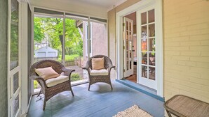 A covered porch with two wicker chairs and a rug. - Elegant Charles Town Home: Grill, Walk Dtwn! (Charles Town)