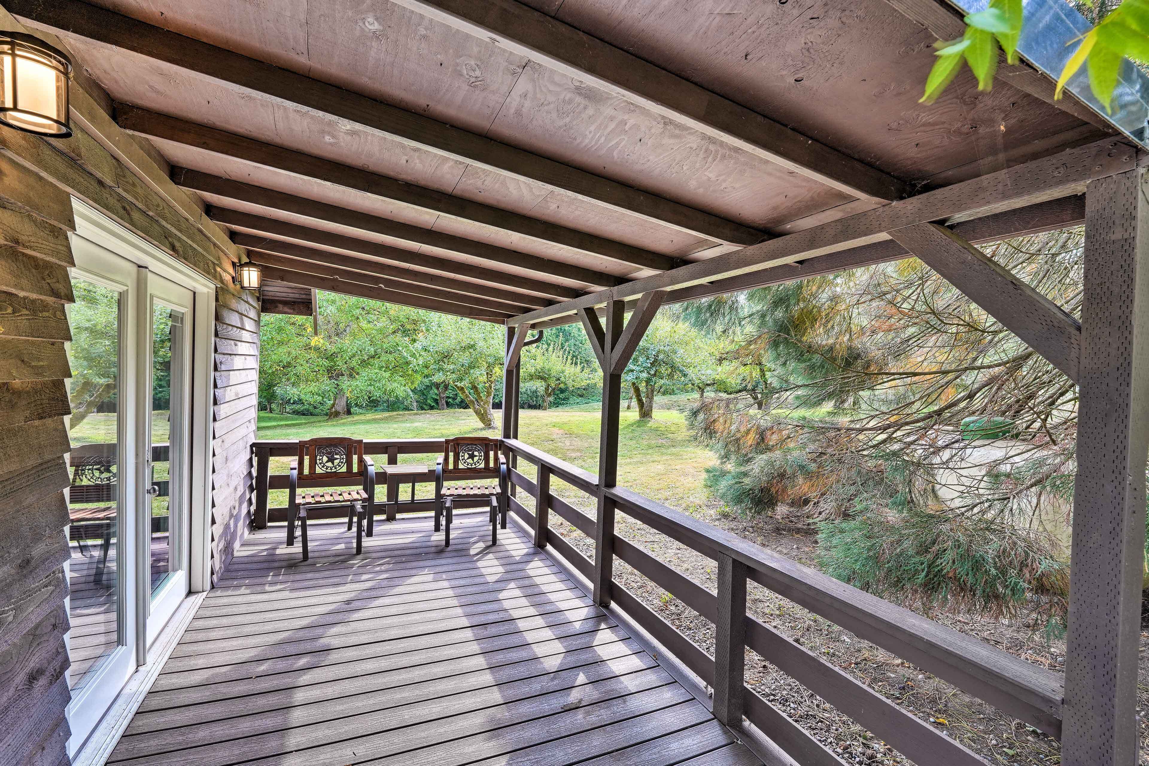 A wooden deck with a railing, a bench, and a table.