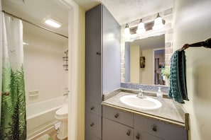 A bathroom with a bathtub, toilet, vanity with a sink, and a mirror. - Cozy Sevierville Condo: Balcony, Pool Access (Sevierville)