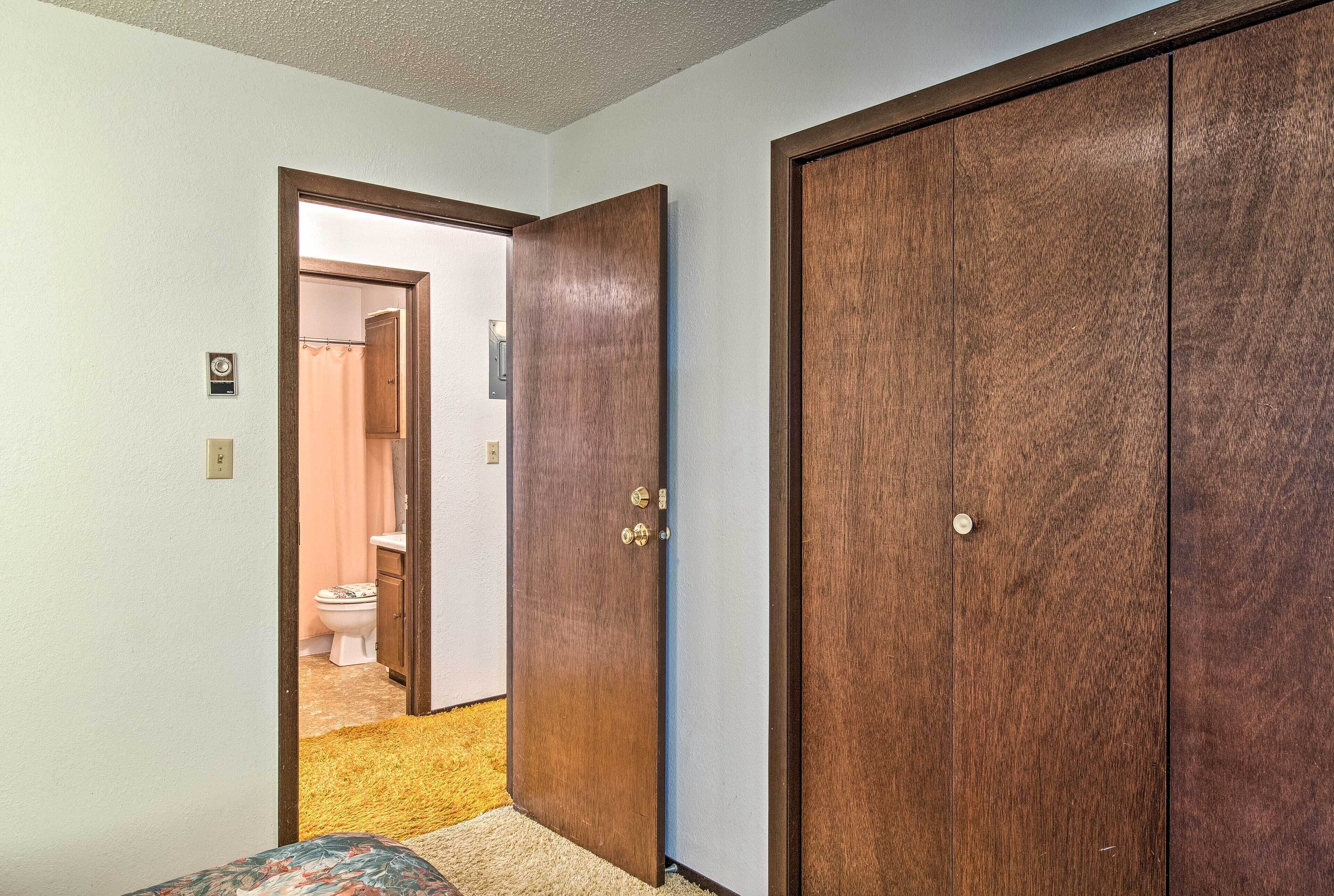 Un couloir avec une porte en bois donnant sur une salle de bain.