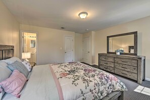 A bedroom with a bed, dresser, and a large mirror. - Glen Cove Home: Walk to Boardwalk + Dining! (Glen Cove)