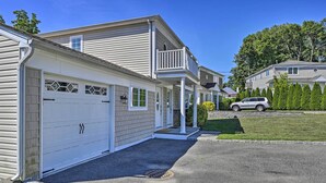 A row of single-story houses with attached garages, a well-maintained lawn, and a clear sky. - Glen Cove Home: Walk to Boardwalk + Dining! (Glen Cove)