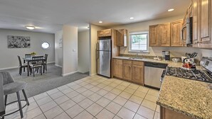 A modern kitchen with granite countertops, stainless steel appliances, and wooden cabinets. - Glen Cove Home: Walk to Boardwalk + Dining! (Glen Cove)