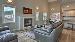 A spacious living room with a fireplace, leather sofas, and a dining area. - Heart of Black Hills Home by Mickelson Trail! (Hill City)