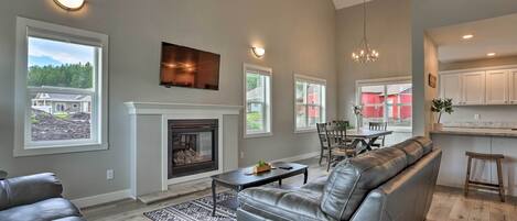 A spacious living room with a fireplace, leather sofas, and a dining area.