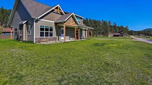 A modern two-story house with a large front porch, a covered entryway, and a sloped roof. - Heart of Black Hills Home by Mickelson Trail! (Hill City)