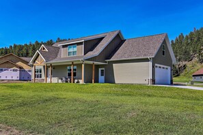 A two-story house with a garage, a covered porch, and a well-maintained lawn. - Heart of Black Hills Home by Mickelson Trail! (Hill City)