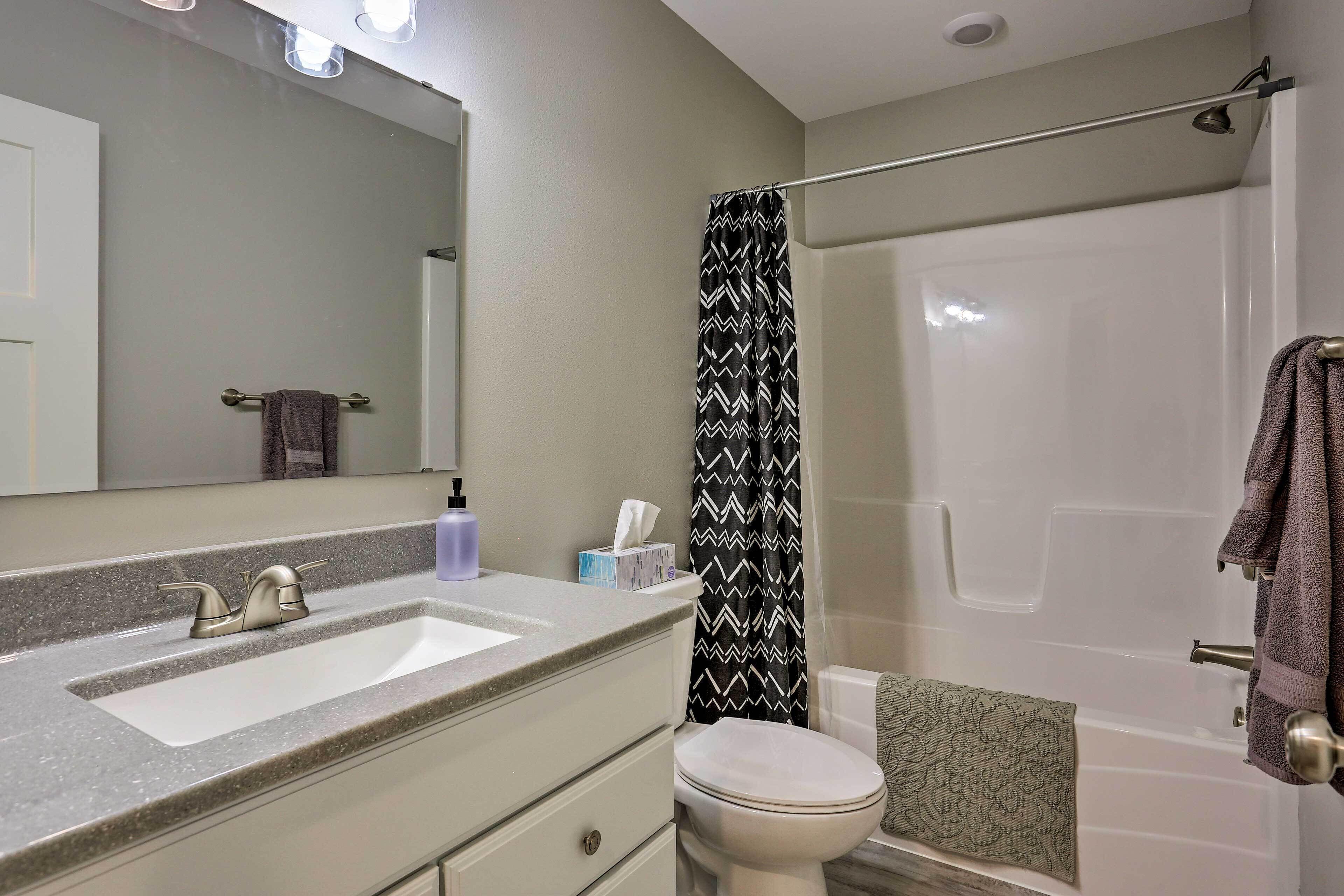 A bathroom with a sink, toilet, and shower.