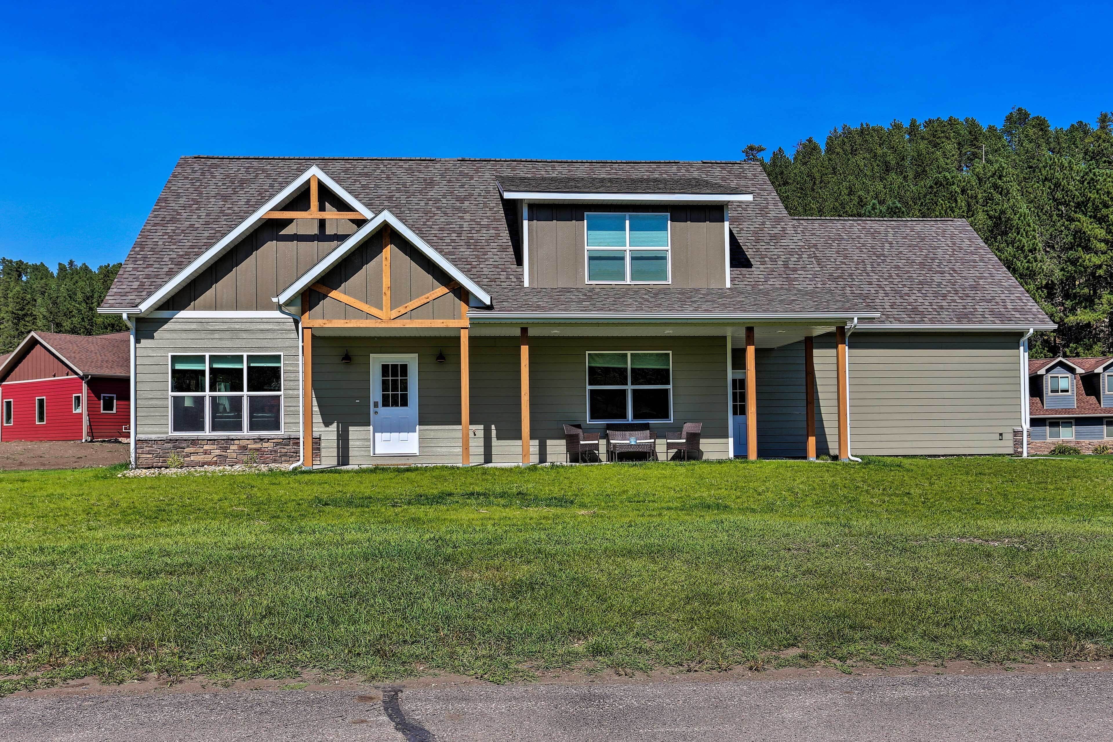 A two-story house with a front porch, a garage, and a well-maintained lawn.