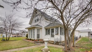 A two-story house with a front porch, a small garden, and a birdbath. - Historic Alexandria Home w/ Private Yard! (Alexandria)