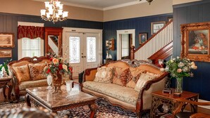 A traditional living room with a sofa, coffee table, and decorative vases. - Historic Huntington Home w/ Pond & Flower Gardens! (Huntington)