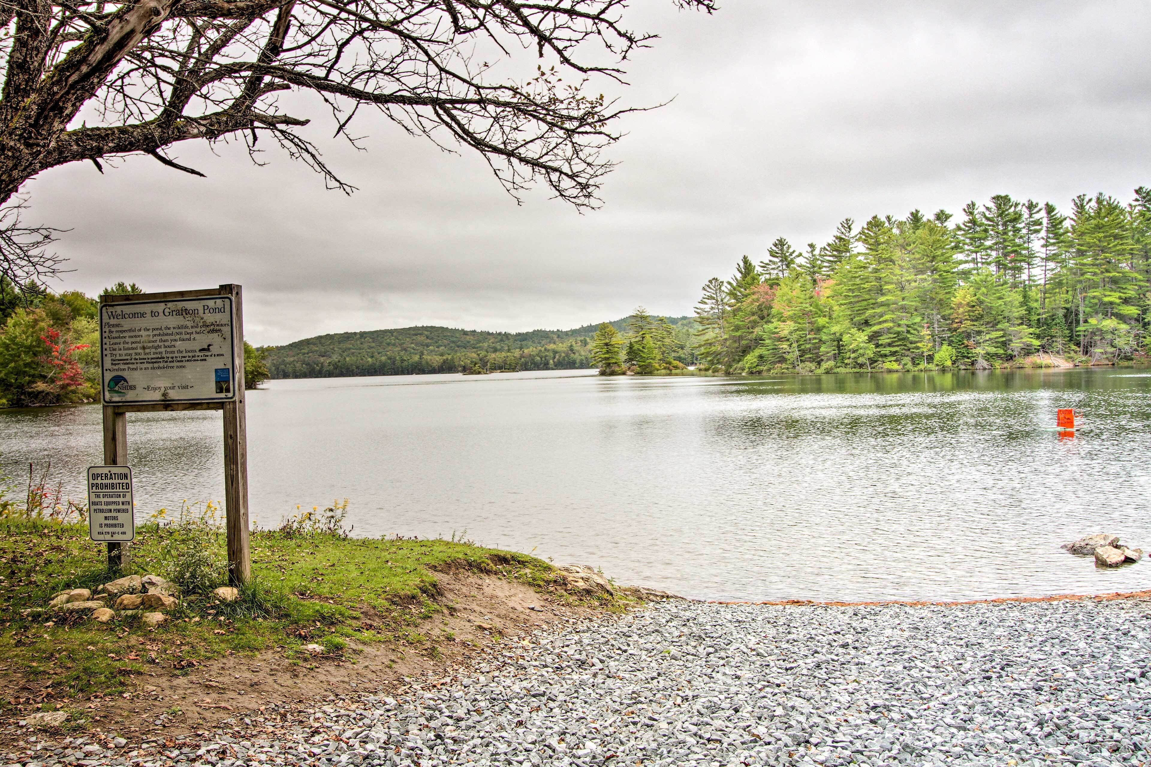 A tranquil lake with a wooden signboard by the shore, indicating it's a wildlife-friendly area.