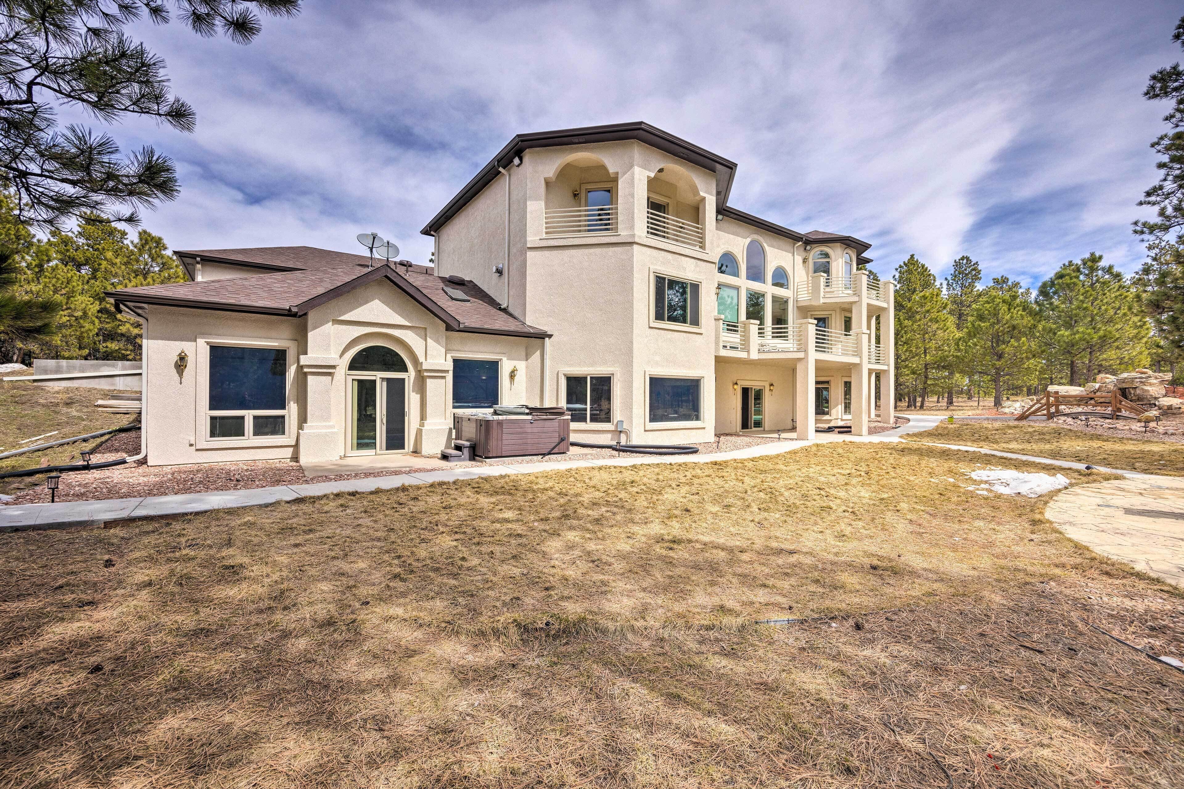 A two-story house with a large front yard and a hot tub.